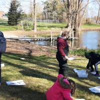 Students outside learning on the pond
